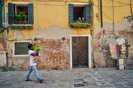 מסע בן 100 צעדים. | עובד  הודי  ונציה  ירקות  סבל  ארגז  דלת  קיר לבנים  איטליה 